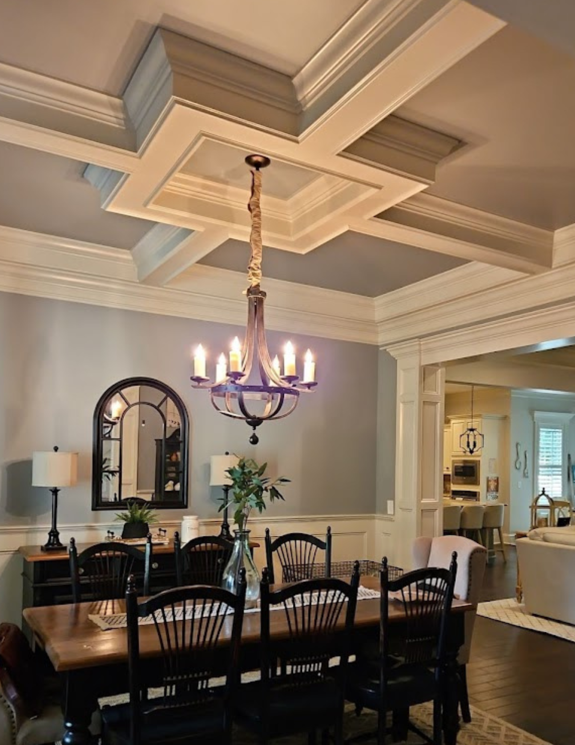 A dining room with a table and chairs and a chandelier hanging from the ceiling