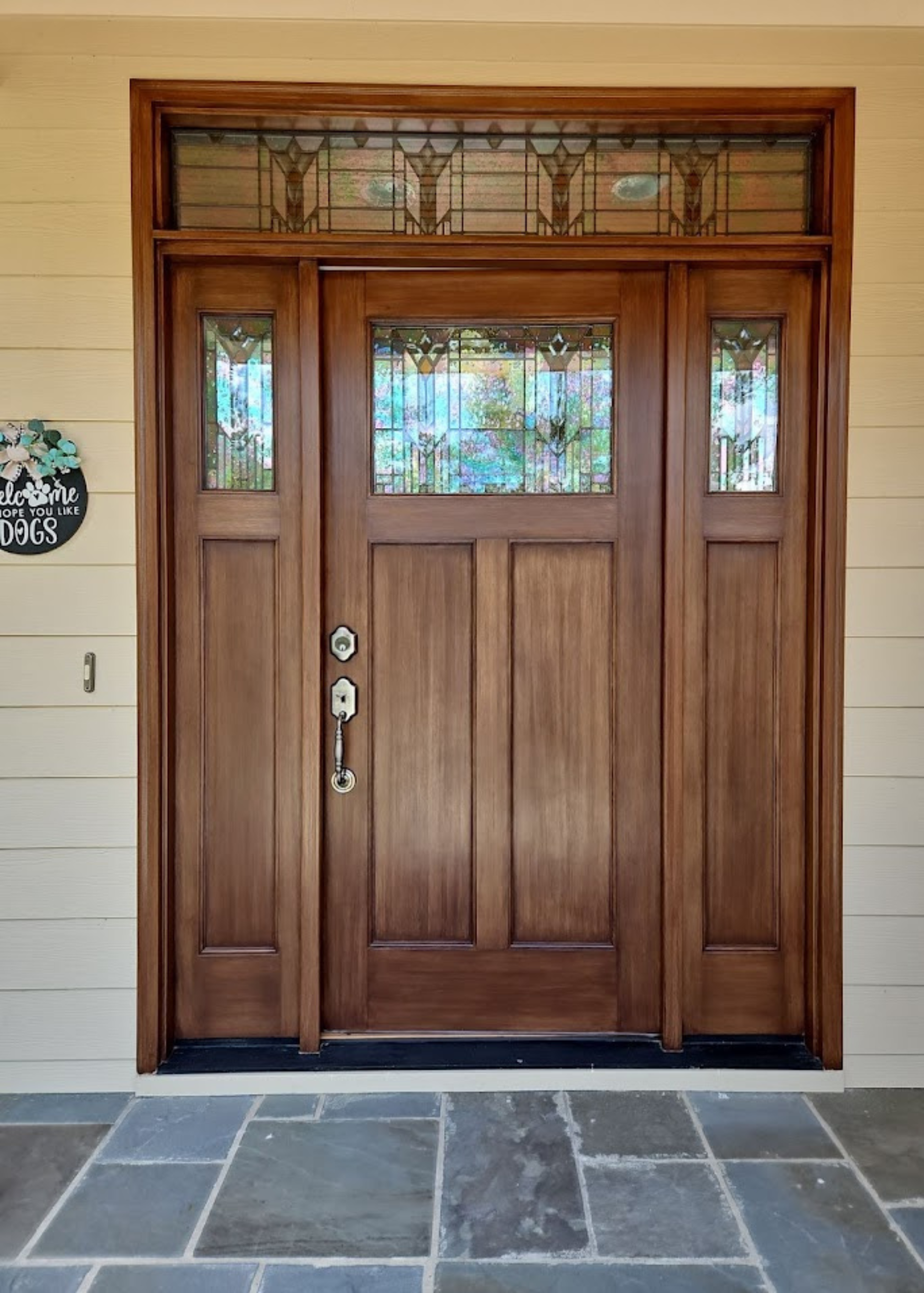 A large wooden door with a stained glass window