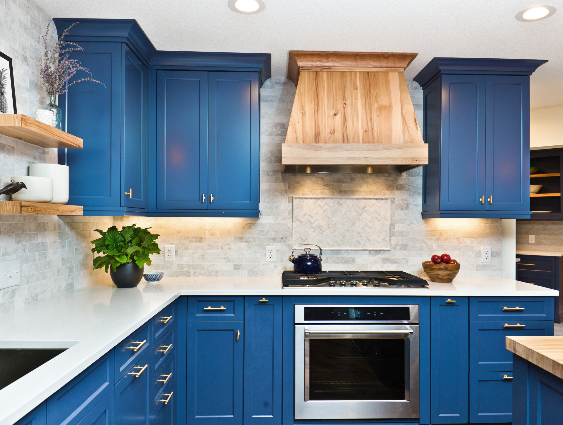 A kitchen with blue cabinets and stainless steel appliances.