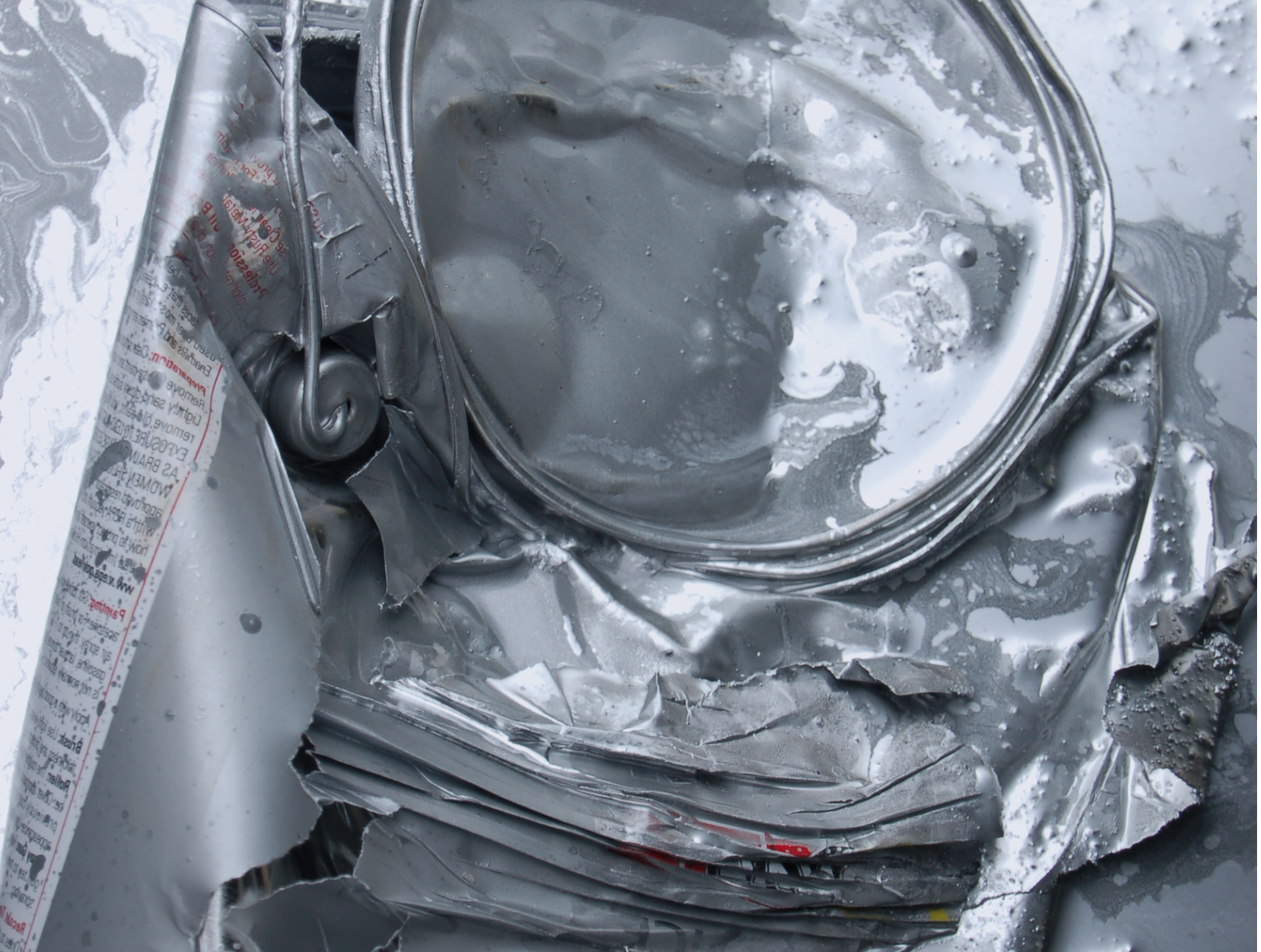 A close up of a broken aluminum can on a table.