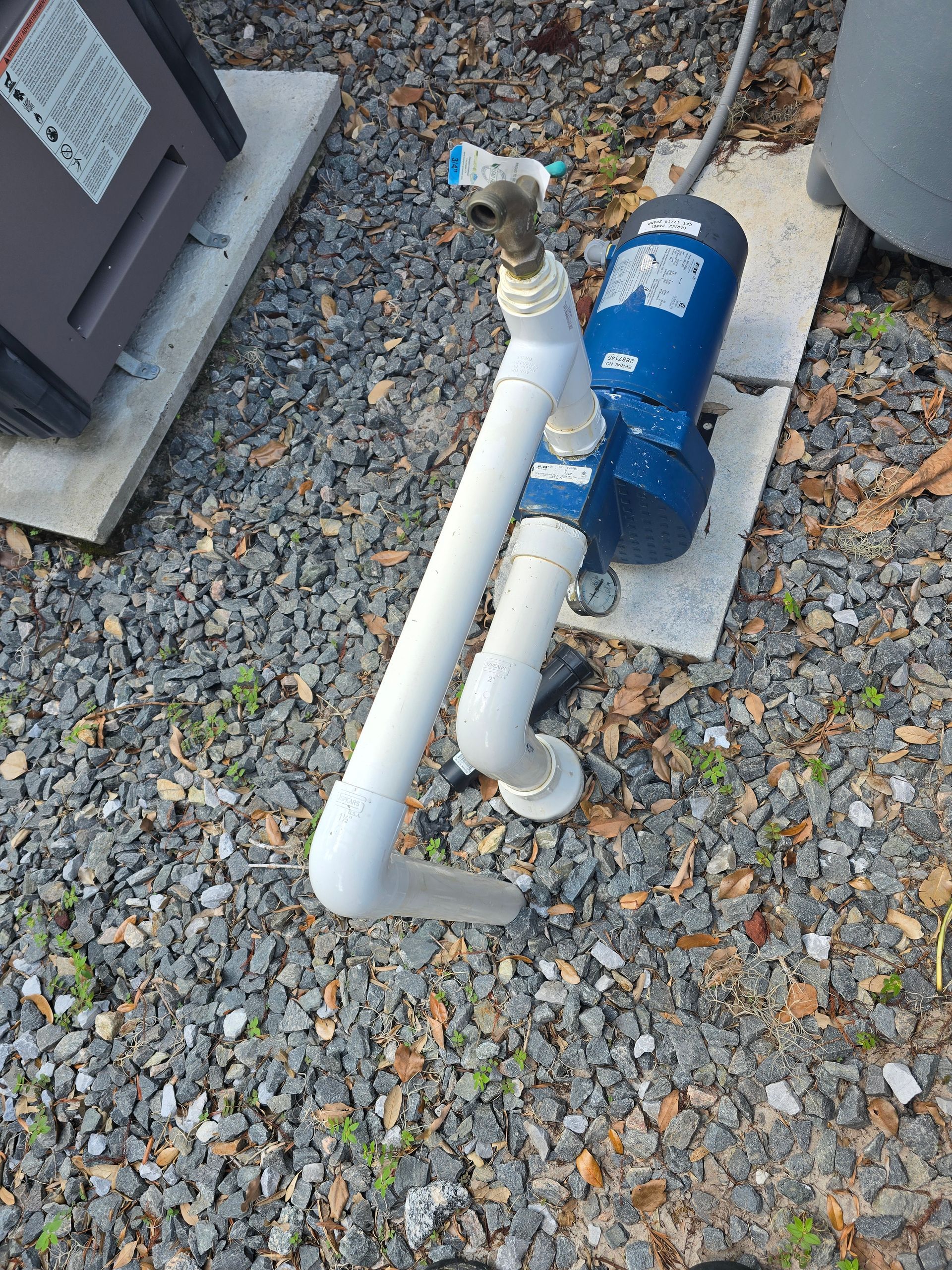 A man is planting trees in a garden.
MT Landscaping Service