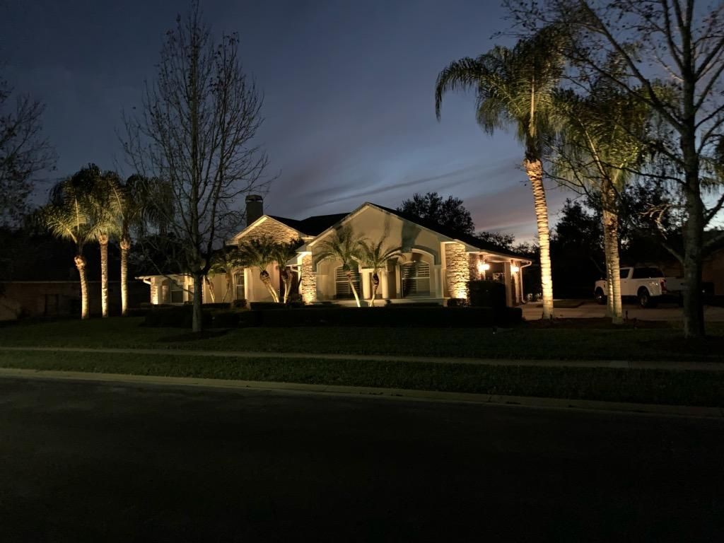 A man is cutting a bush with a hammer in a garden. MT Landscaping Service