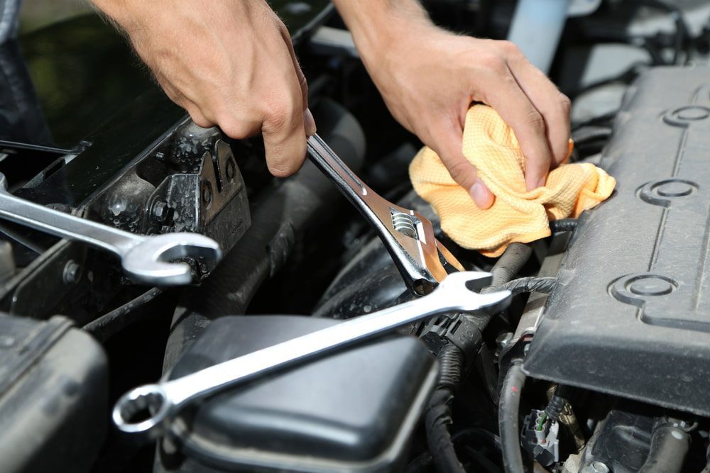 A Person Is Working On A Car Engine With A Wrench — Mullumbimby Automotive in Mullumbimby, NSW