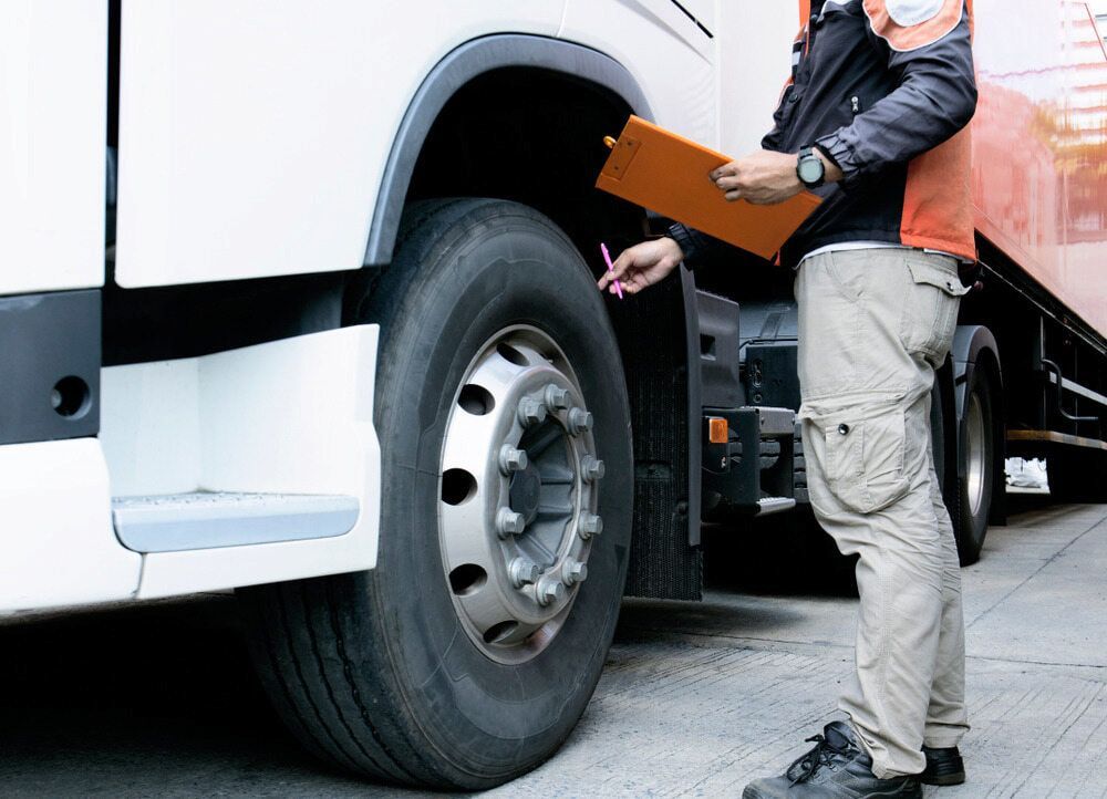 A Man Is Standing Next To A Truck Holding A Clipboard — Mullumbimby Automotive in Mullumbimby, NSW