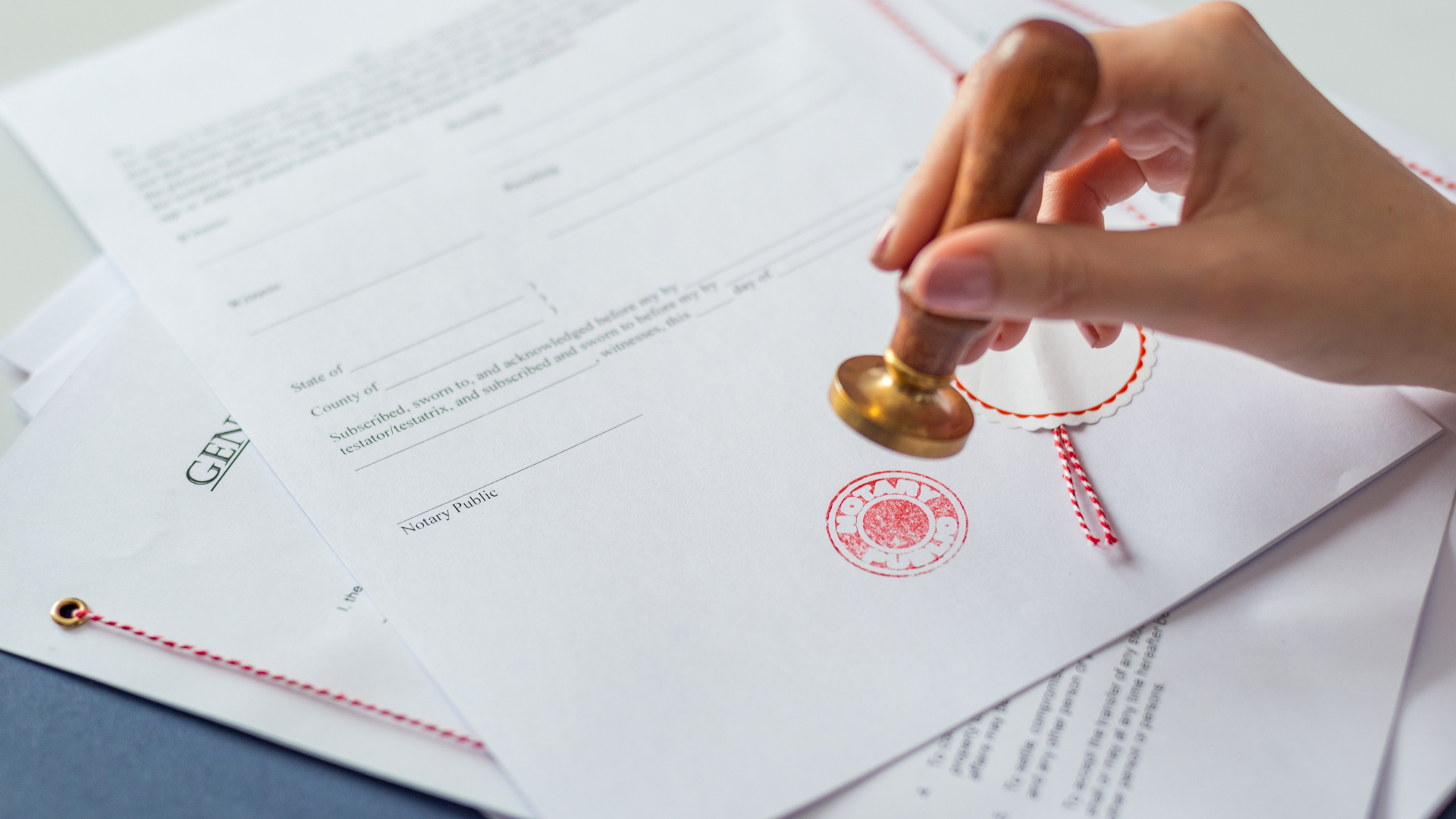 A person is stamping a document with a wax seal.