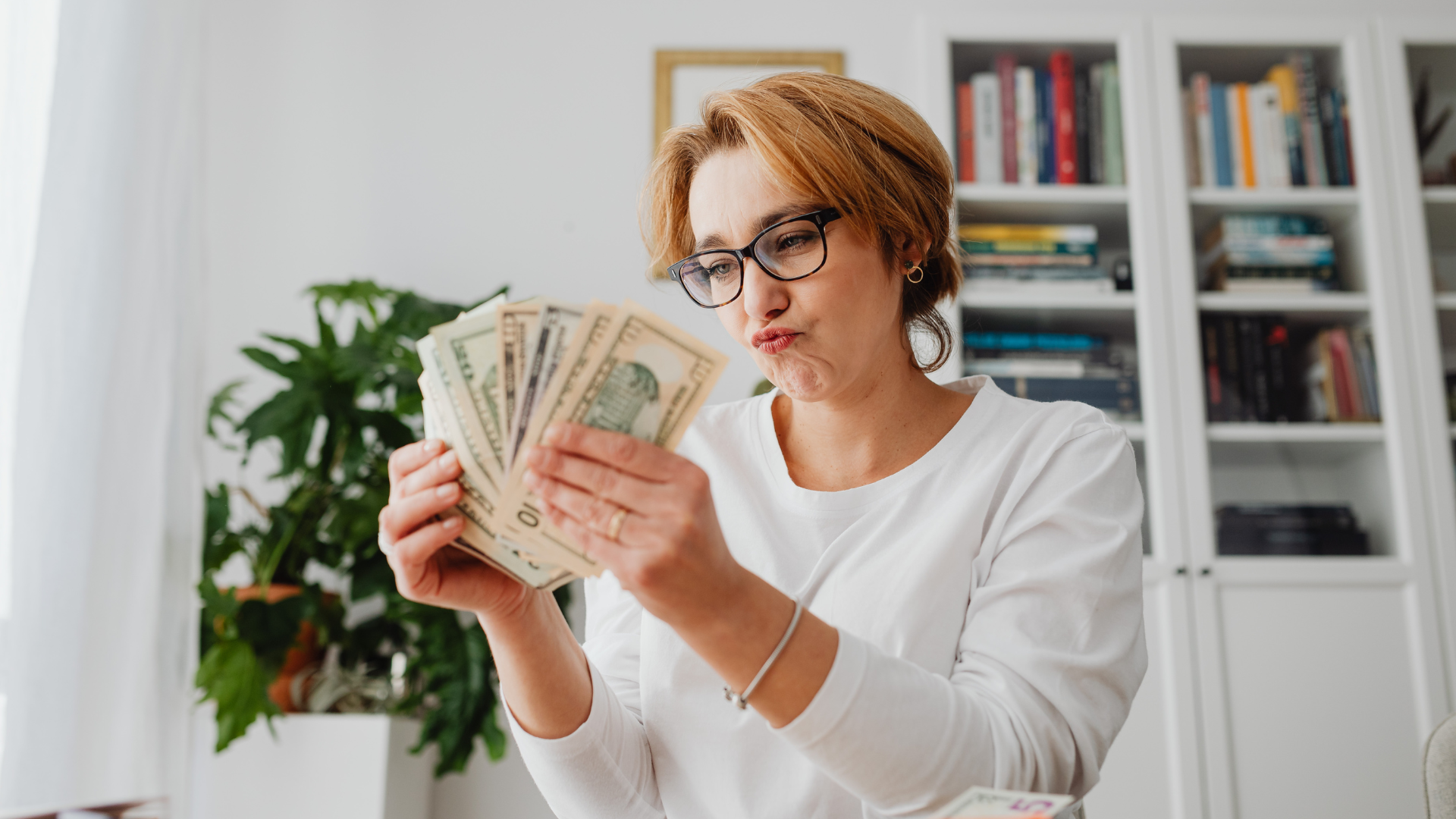 A woman is holding a bunch of money in her hands.