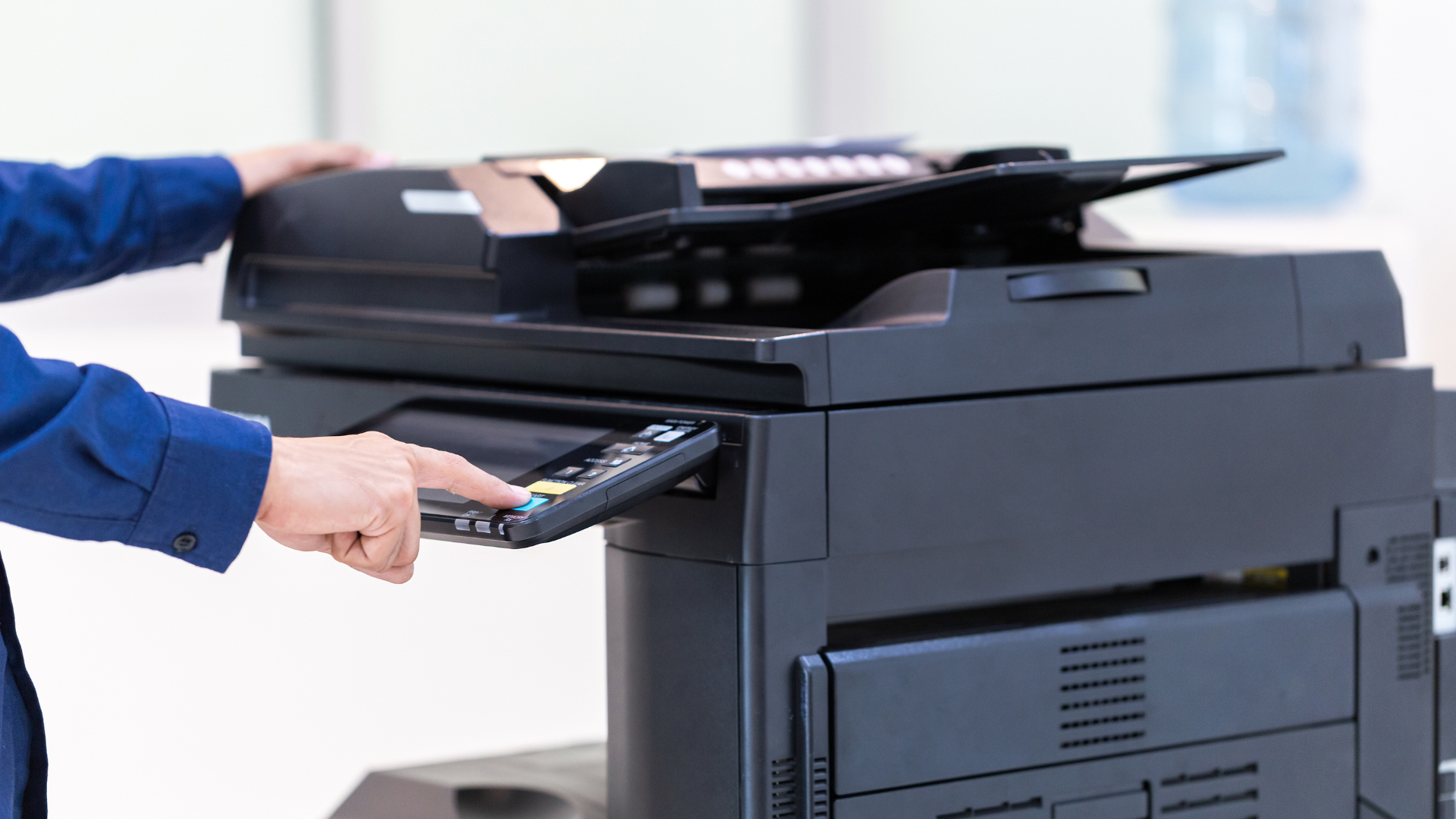 A person is using a remote control to operate a printer.