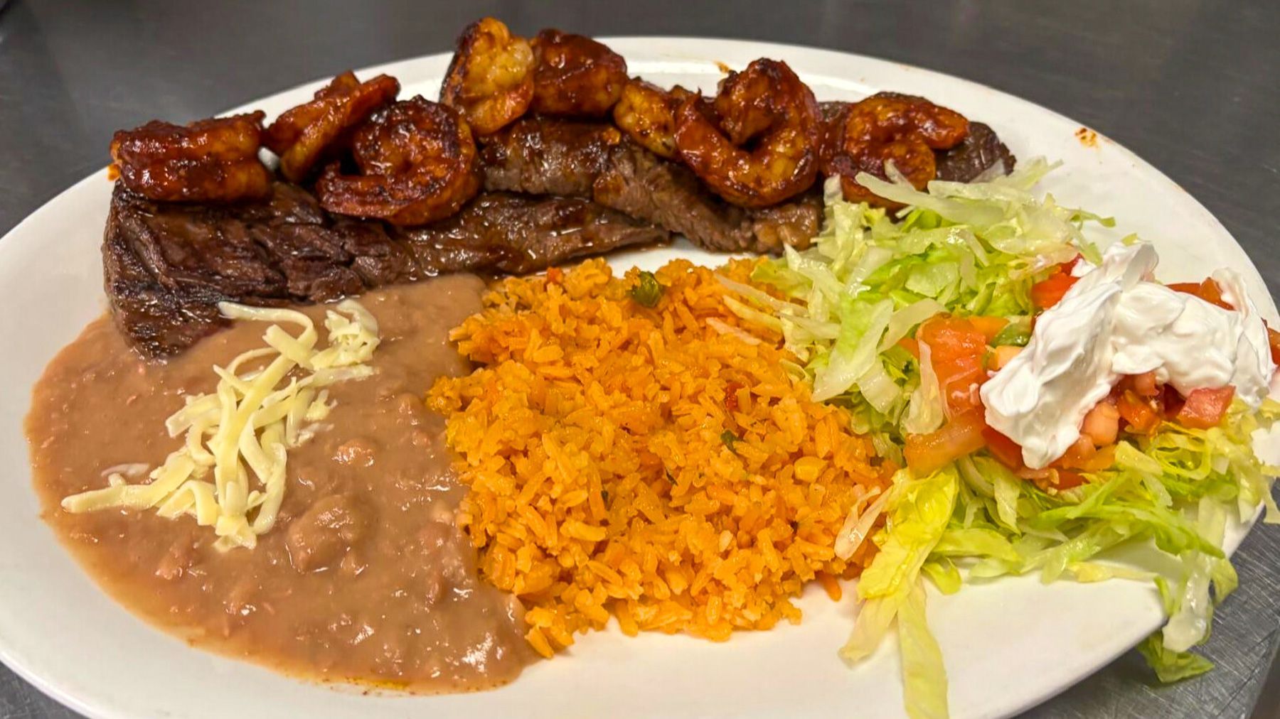 Carne asada and Diablo shrimp dinner with rice, beans, and salad