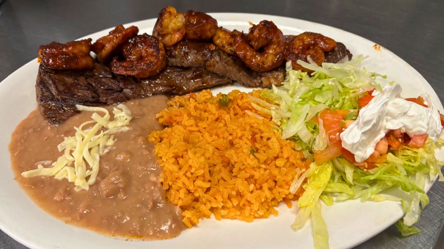Carne asada and diablo shrimp dinner with rice, beans, and salad