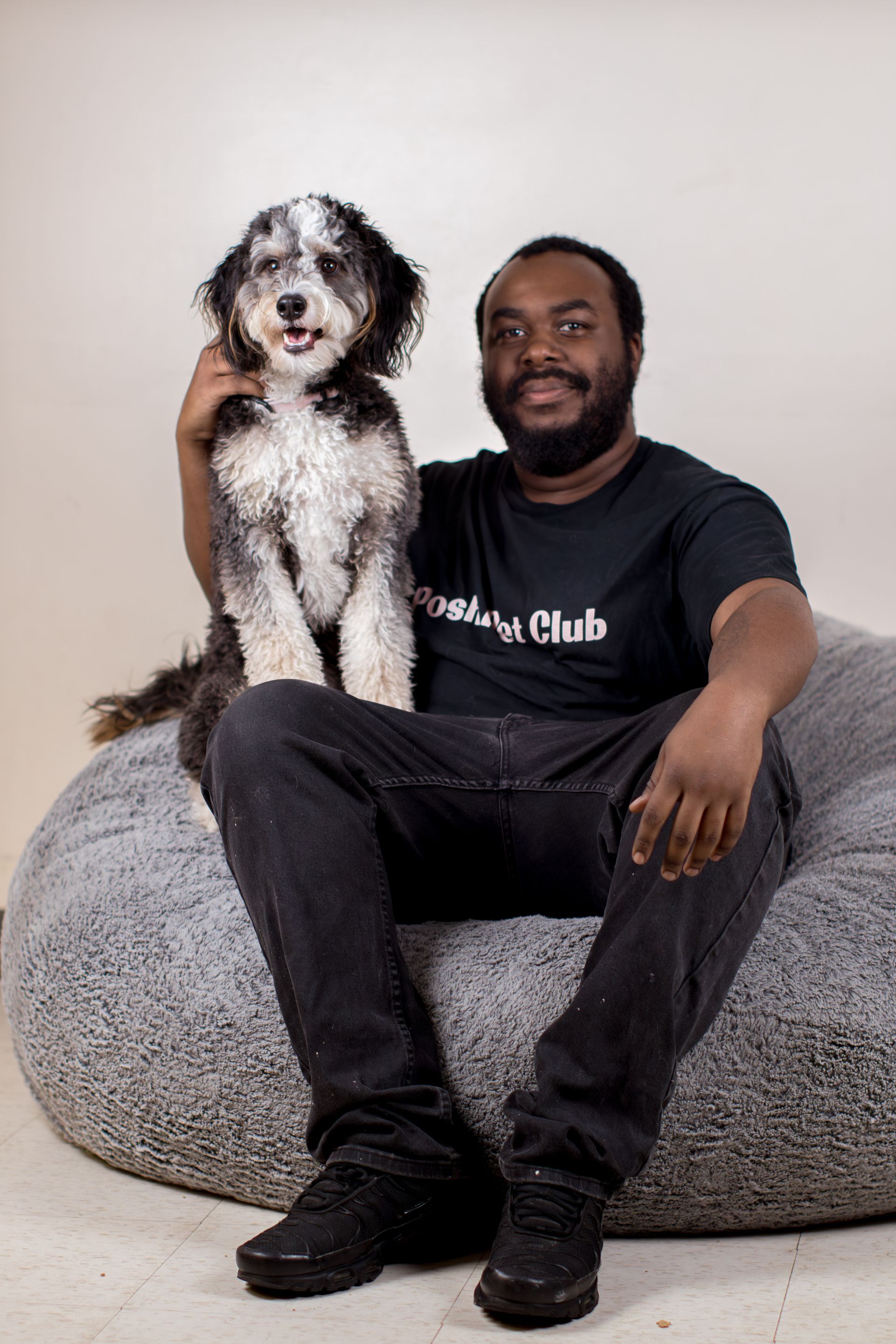 Arthur is kneeling next to a white dog