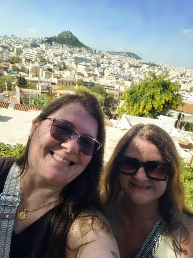 Indoor cruise ship pool area with blue lounge chairs, glass ceiling, and jacuzzi.