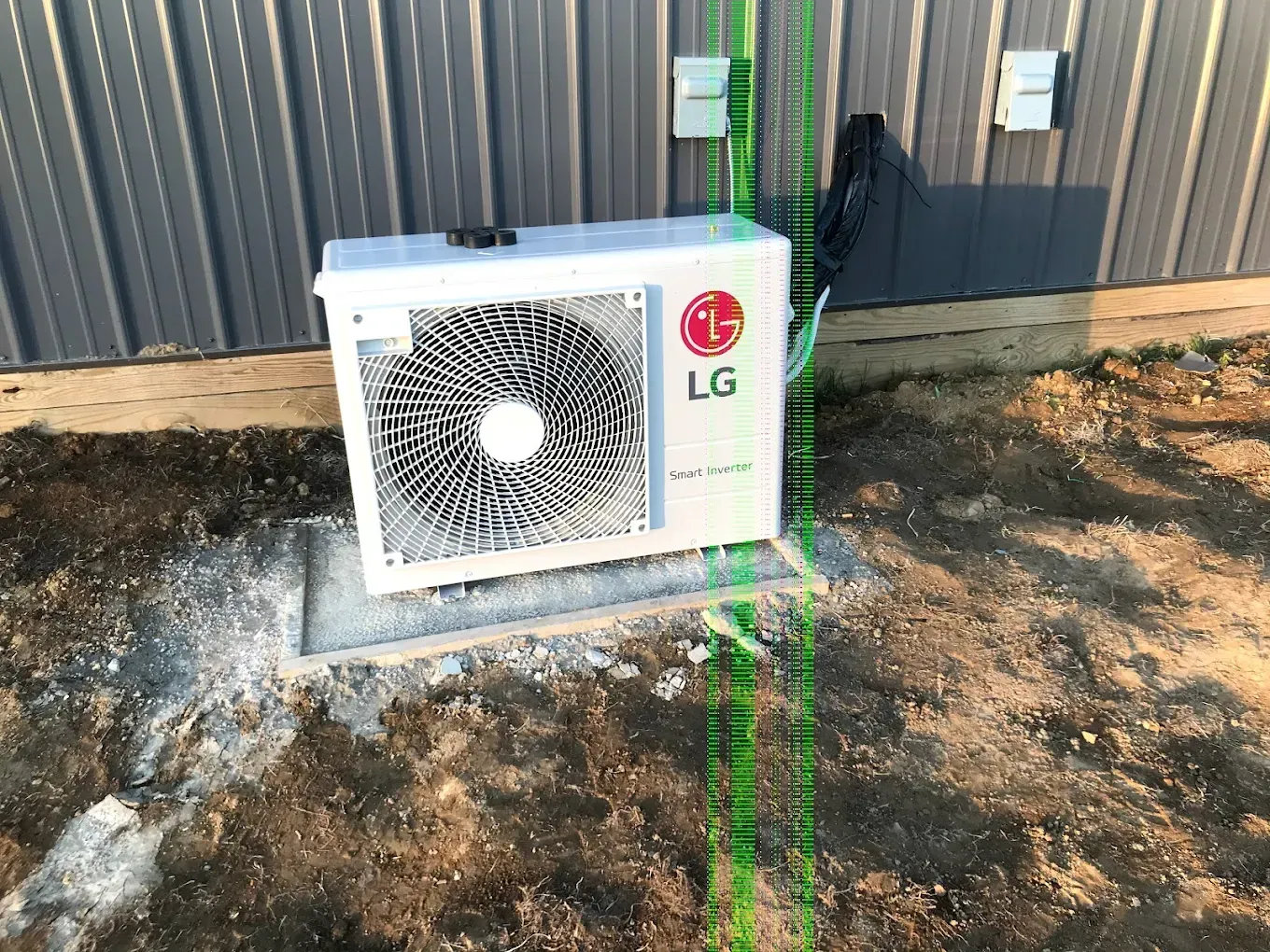 An lg air conditioner is sitting outside of a building.