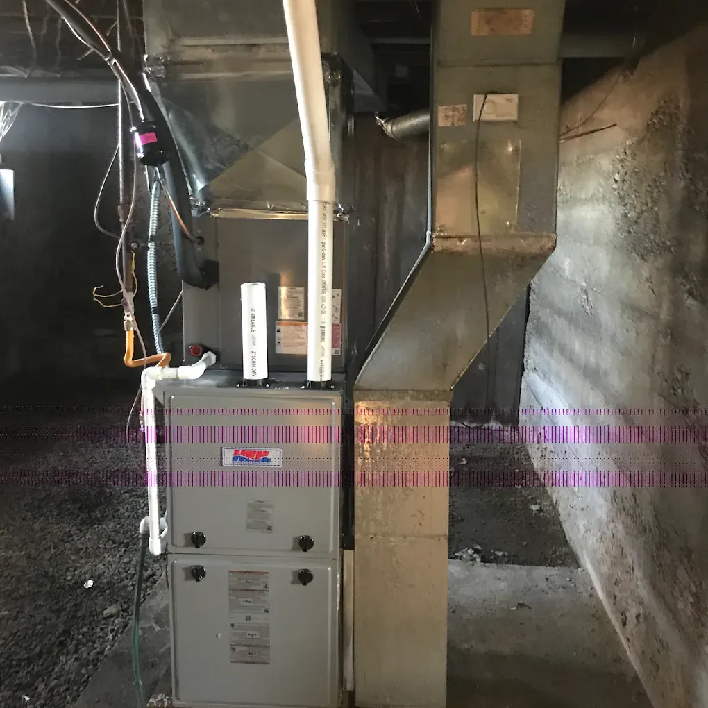 An air conditioner is sitting in a basement next to a wall.