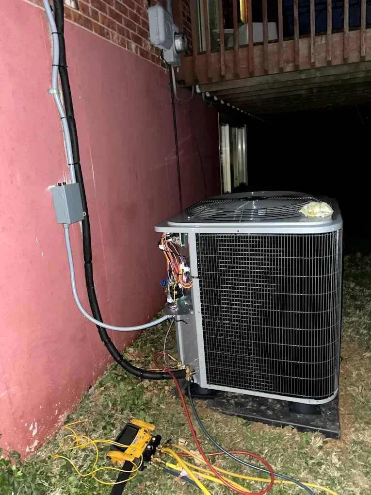 An air conditioner is being installed on the side of a building.