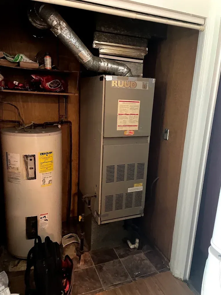 A water heater and an air conditioner are in a closet.
