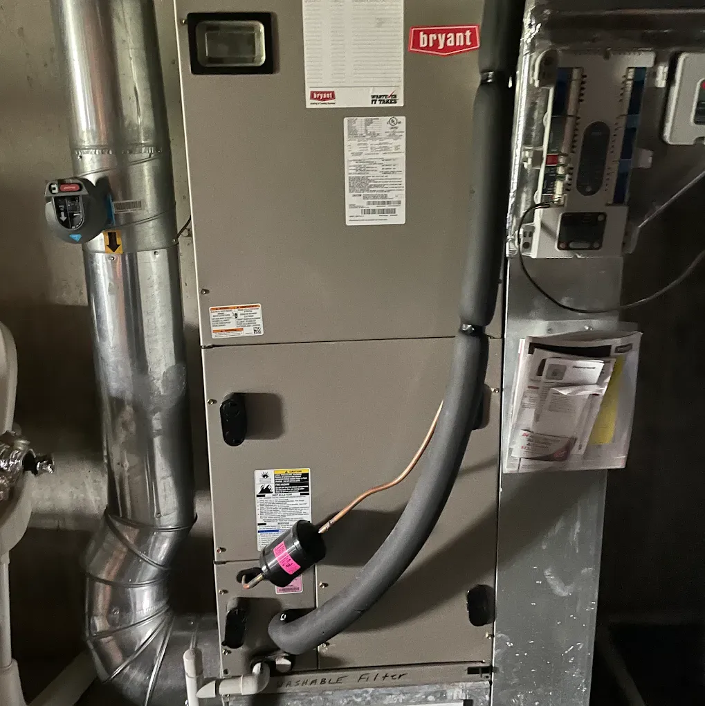 A bryant air conditioner with a hose attached to it