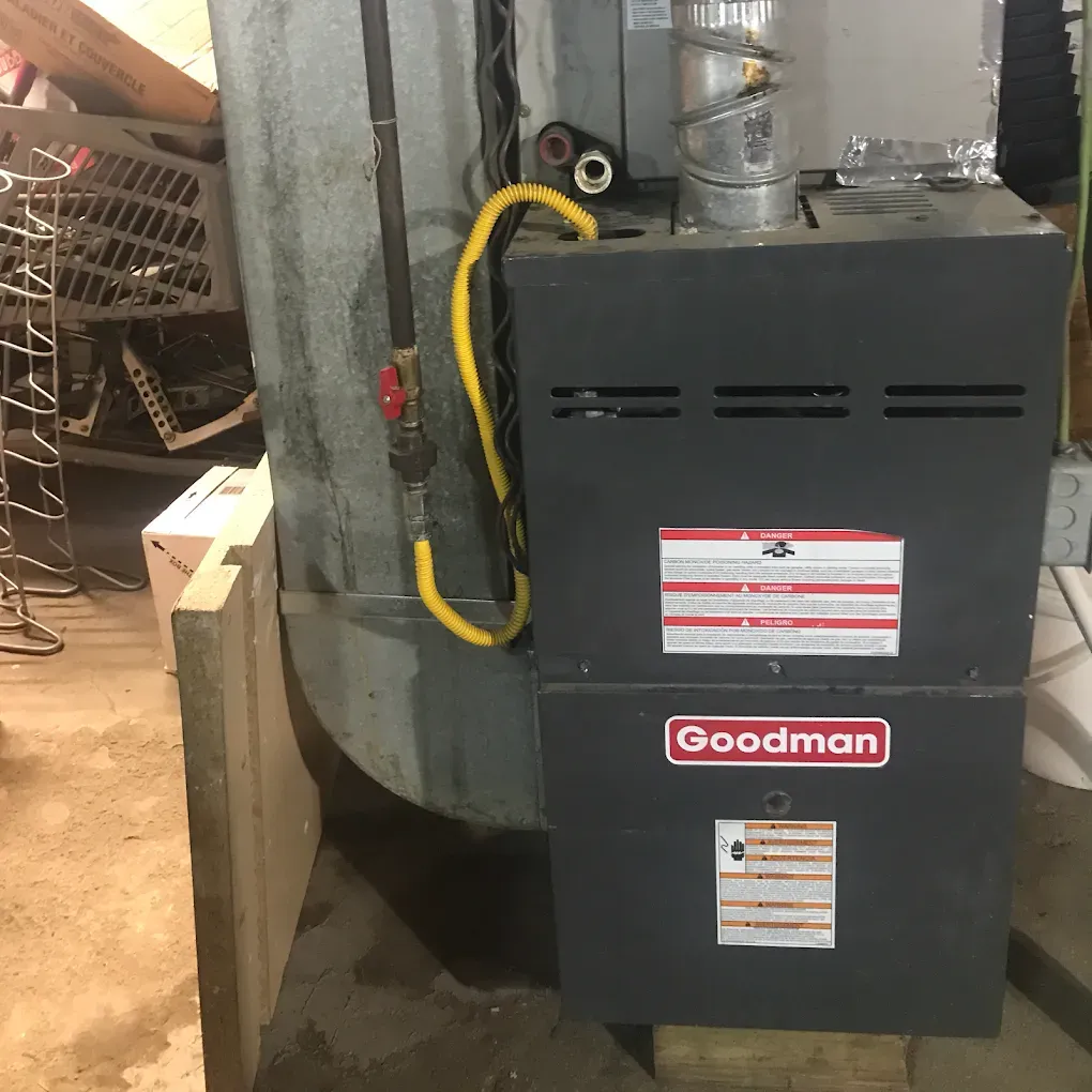 A goodman air conditioner is sitting in a garage