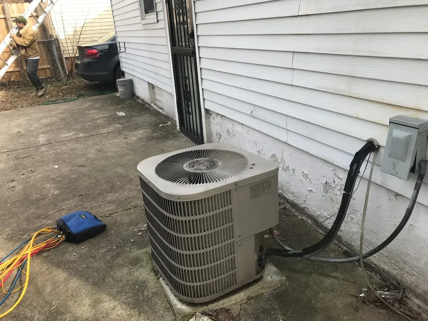 An air conditioner is sitting on the side of a house.