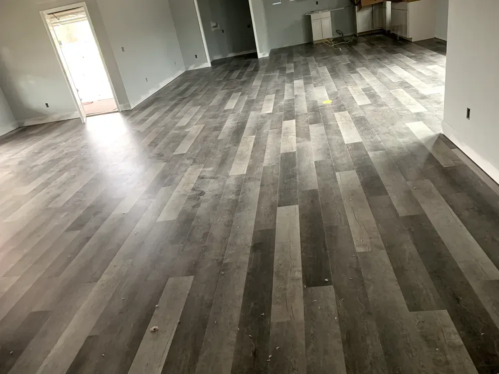 Gray wood-look flooring installed in a room with light gray walls.