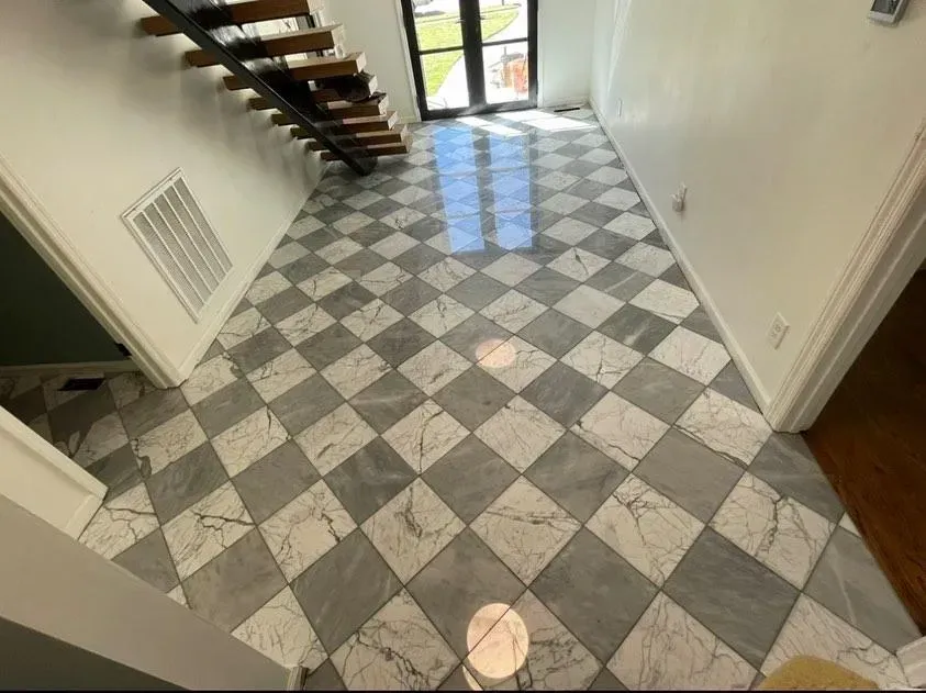 Marble tile floor in a checkered pattern, with a staircase and doorway visible.