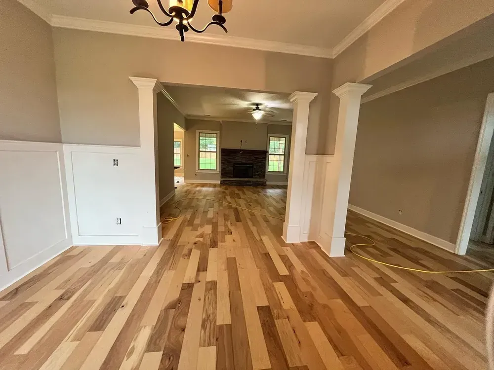 Hardwood floors in a house. Interior view of dining room with light gray walls and white trim.