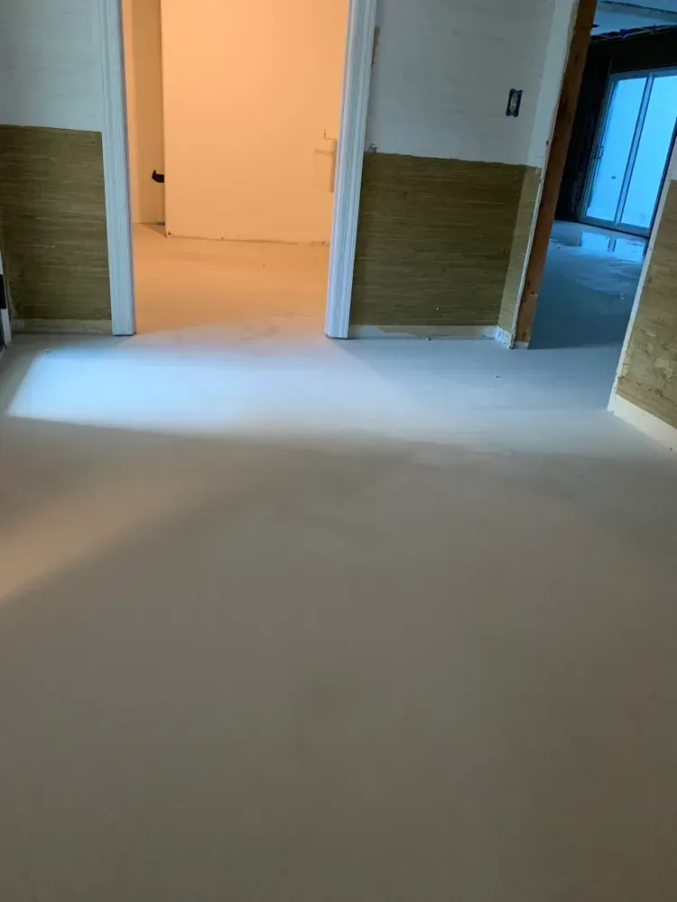 Light-colored floor and walls with wood paneling. Open doorways lead to additional rooms.