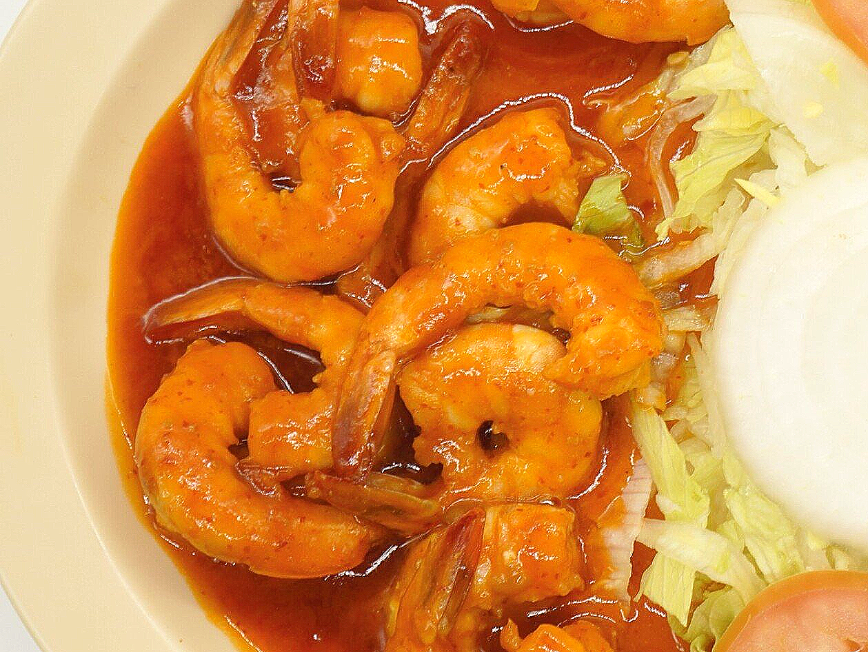 A close up of a plate of food with shrimp and rice.