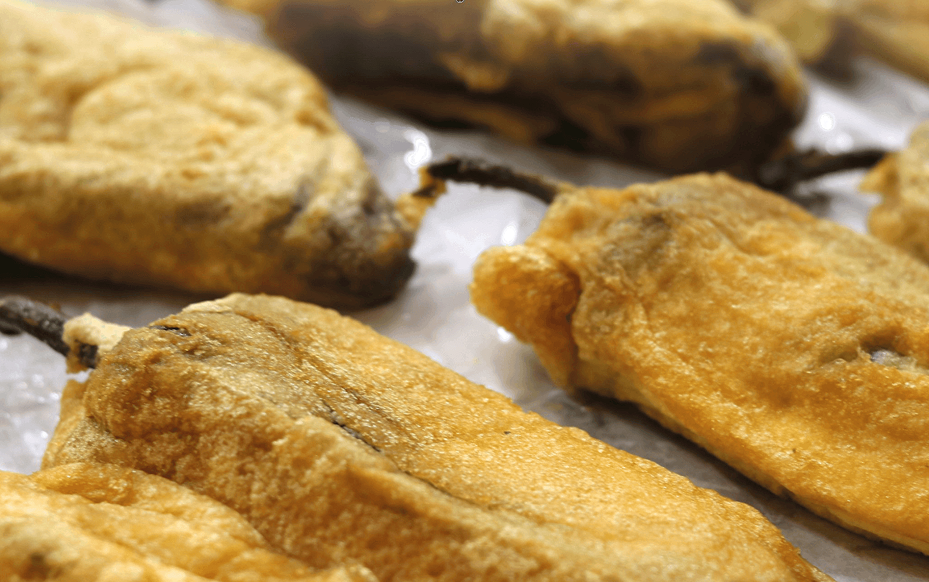 A close up of fried peppers on a table.