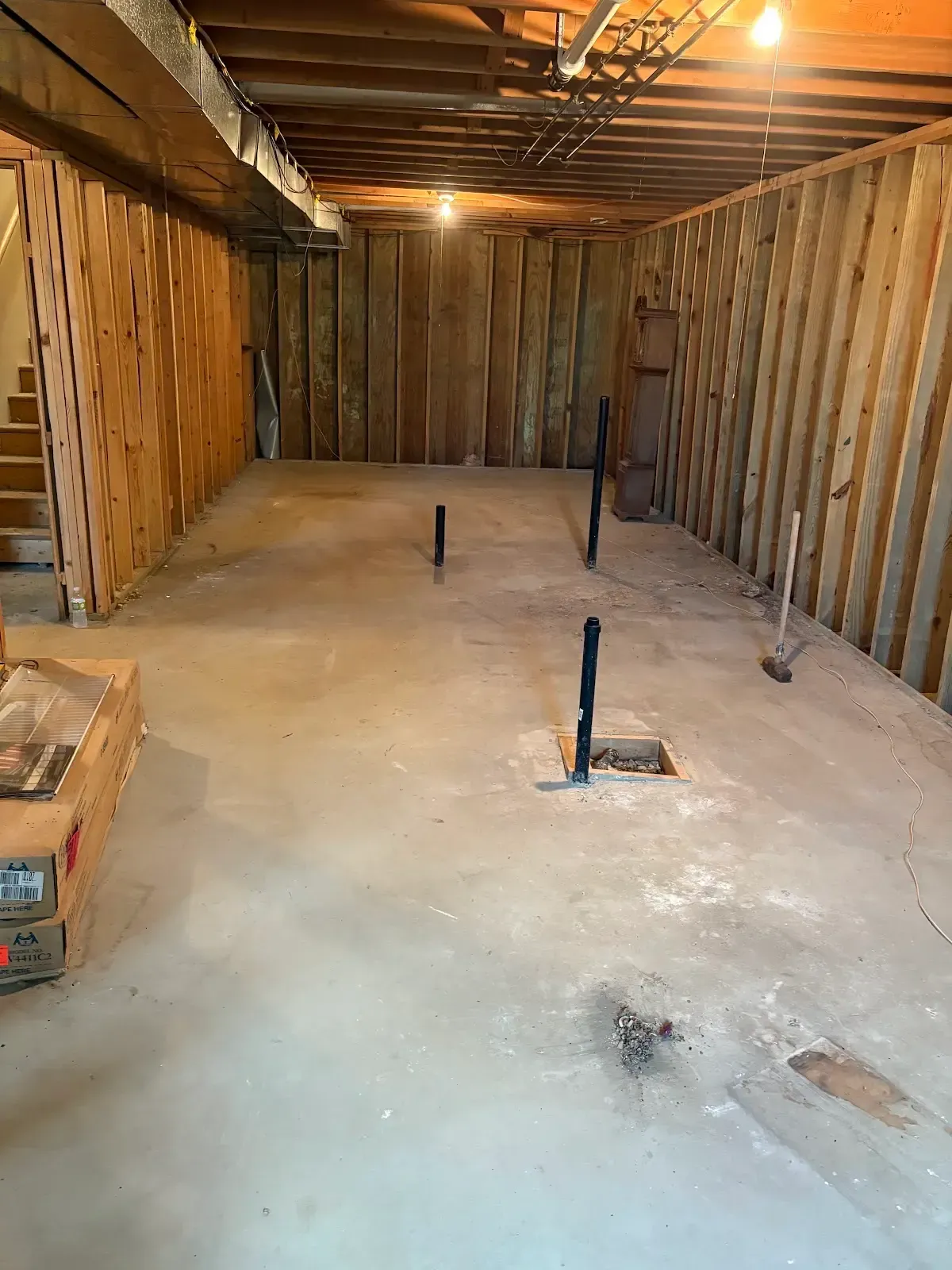 A basement with a concrete floor and wooden walls.