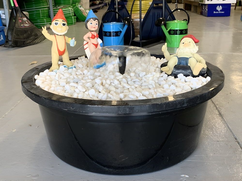 A Black Bowl With Gnomes And Watering Cans In It — Manning Valley Pumps And Irrigation In Gloucester, NSW
