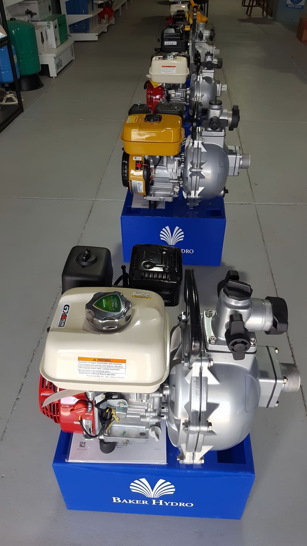 A Row Of Water Pumps Sitting On Top Of Blue Boxes In A Store — Manning Valley Pumps And Irrigation In Forster, NSW