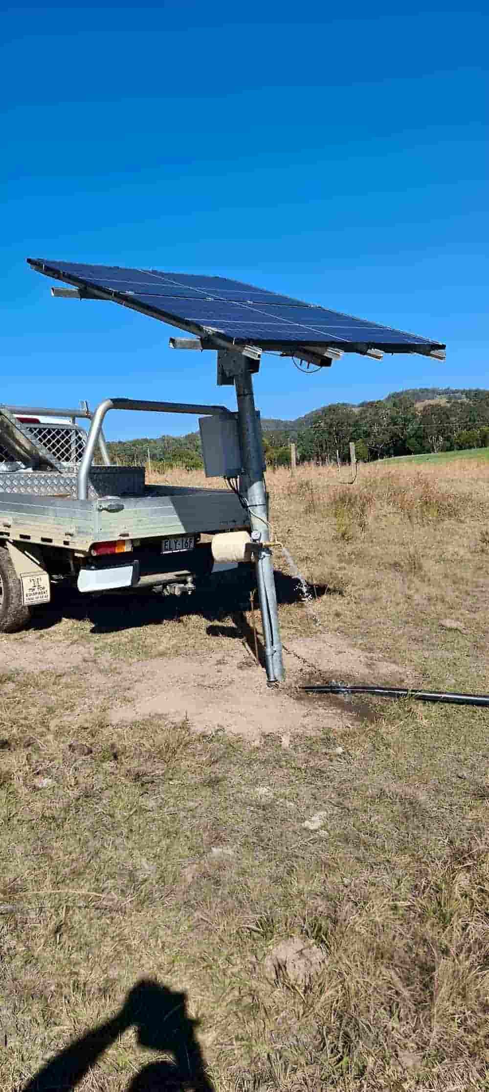 A truck is parked in a field next to a solar panel. — Manning Valley Pumps And Irrigation In Wingham, NSW