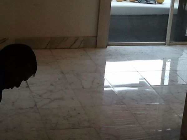 A person standing on a tiled floor in front of a sliding glass door