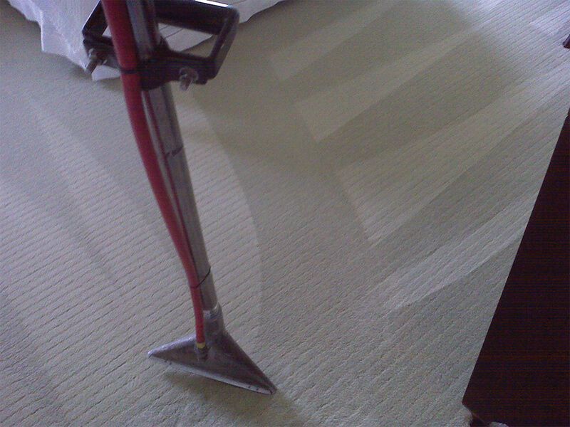 A vacuum cleaner is being used to clean a carpet