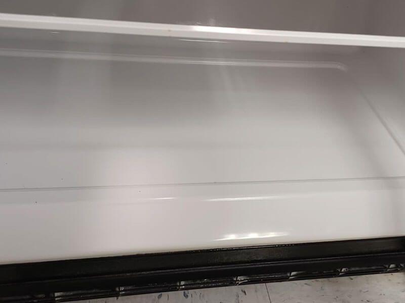 A close up of the inside of an empty refrigerator.