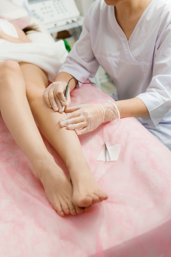 A Woman is Getting a Laser Hair Removal Treatment on Her Legs — Aria Skin & Beauty in Gympie, QLD