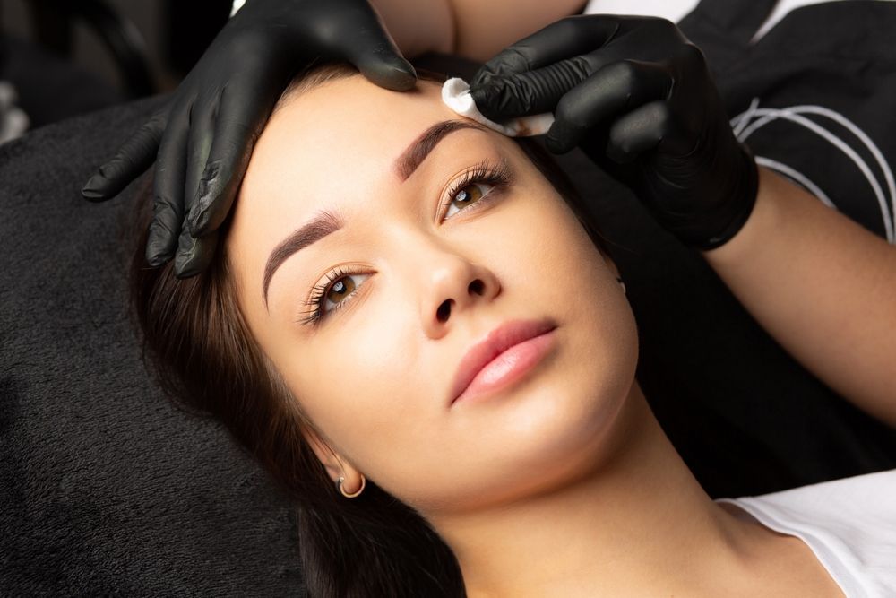 A Woman is Getting a Permanent Makeup Tattoo on Her Eyebrows — Aria Skin & Beauty in Gympie, QLD