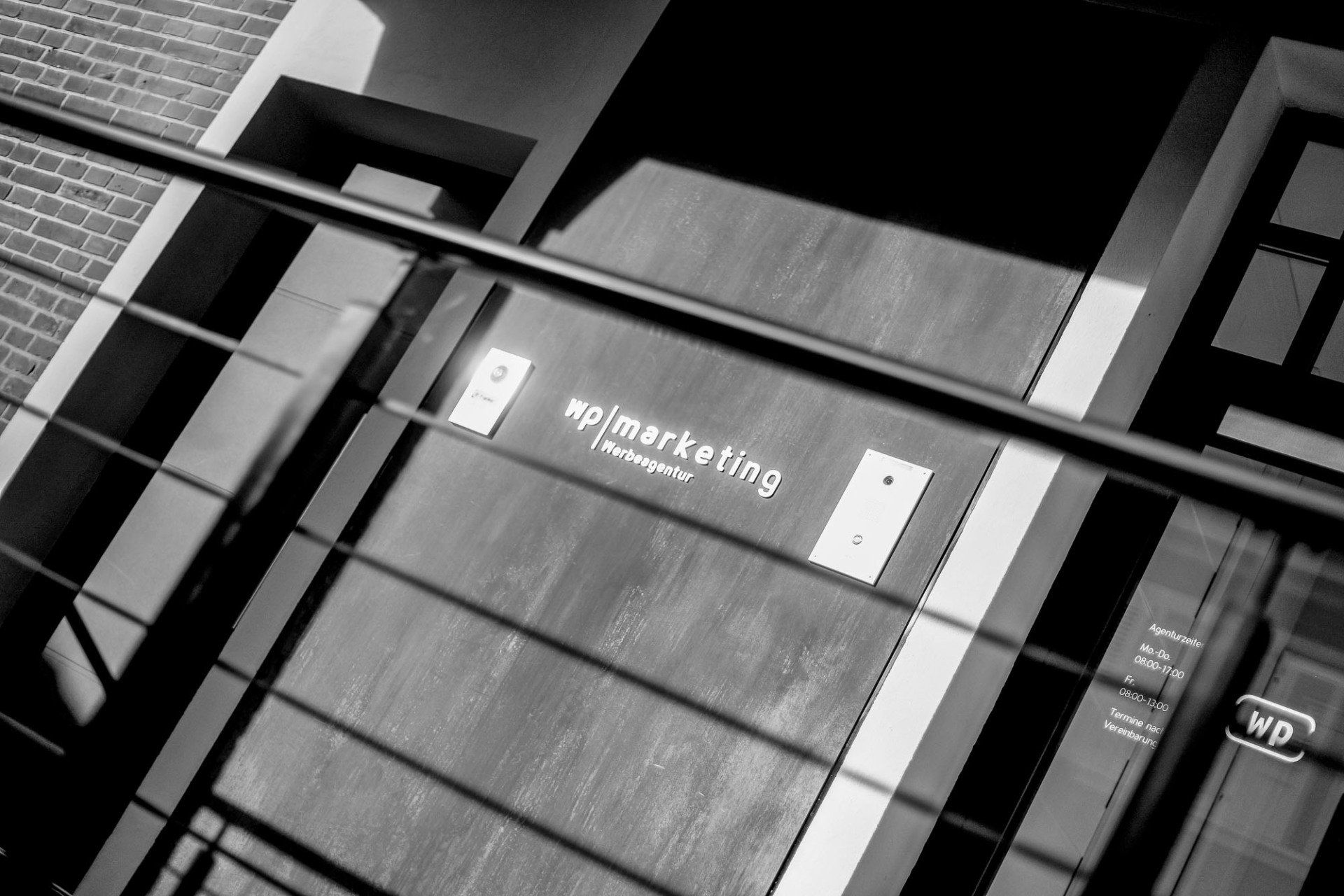 Ein Schwarzweißfoto eines Gebäudes mit einem Schild mit der Aufschrift „WP marketing“.