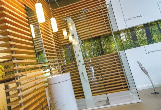 Ein Badezimmer mit Holzwand und Glasdusche