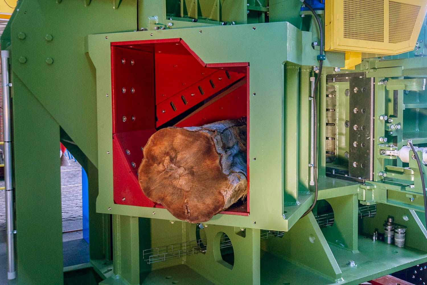 In einer Maschine liegt ein großes Stück Holz.