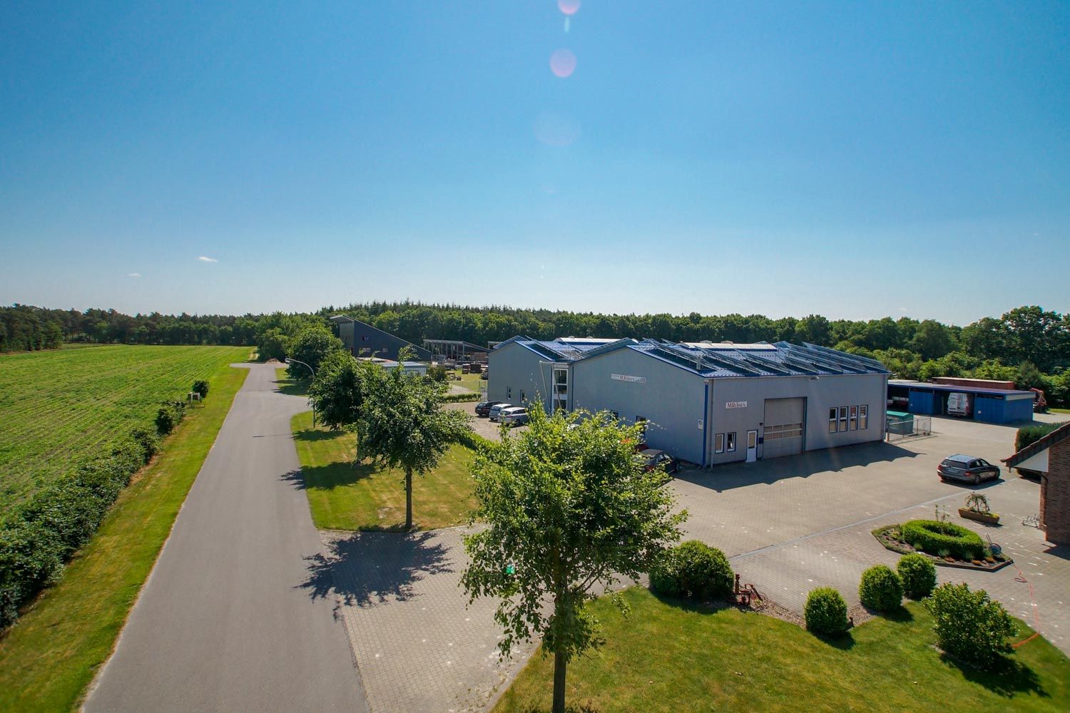 Eine Luftaufnahme eines Gebäudes mit Solarmodulen auf dem Dach.