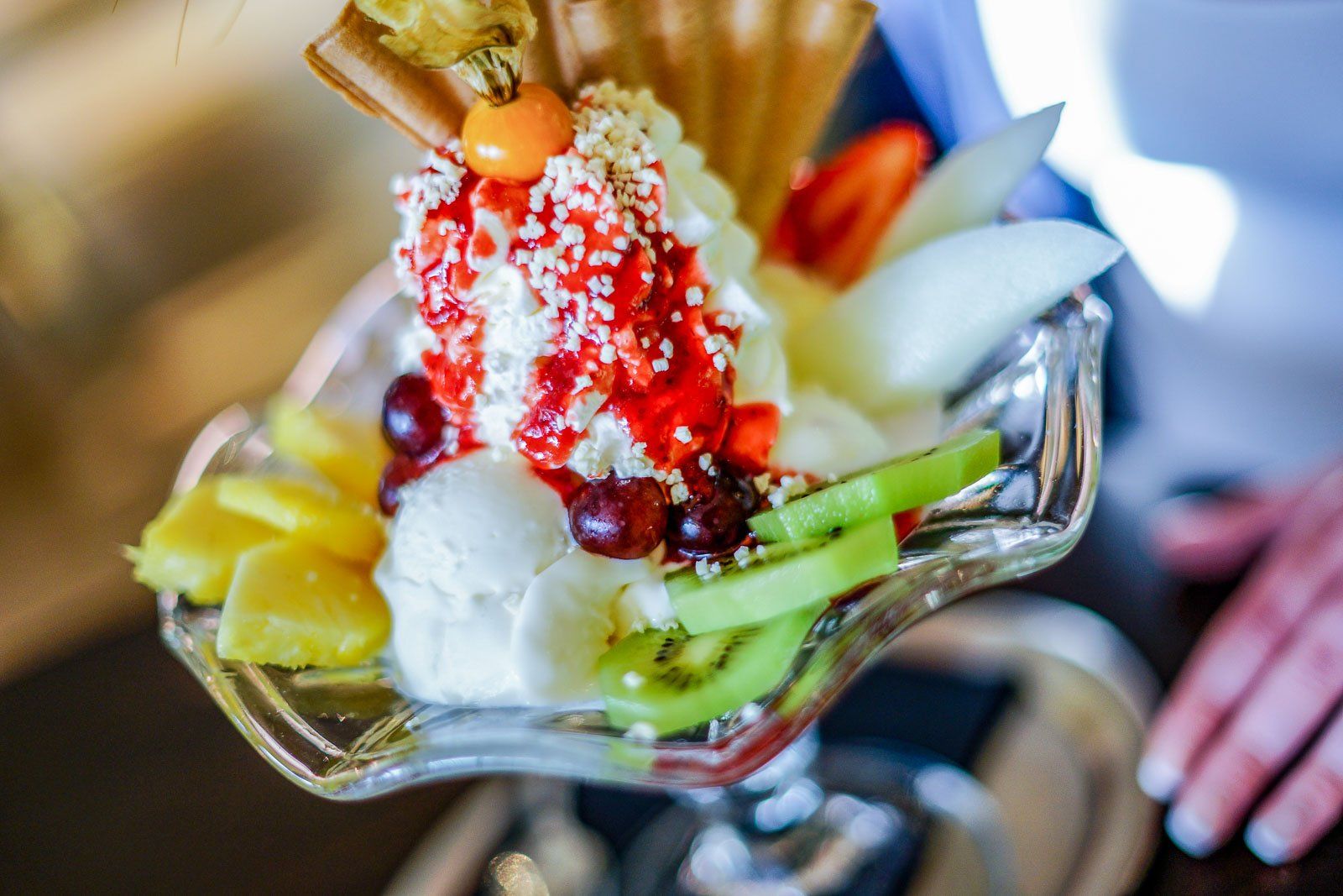 Eine Nahaufnahme einer Glasschale gefüllt mit Eiscreme und Obst.