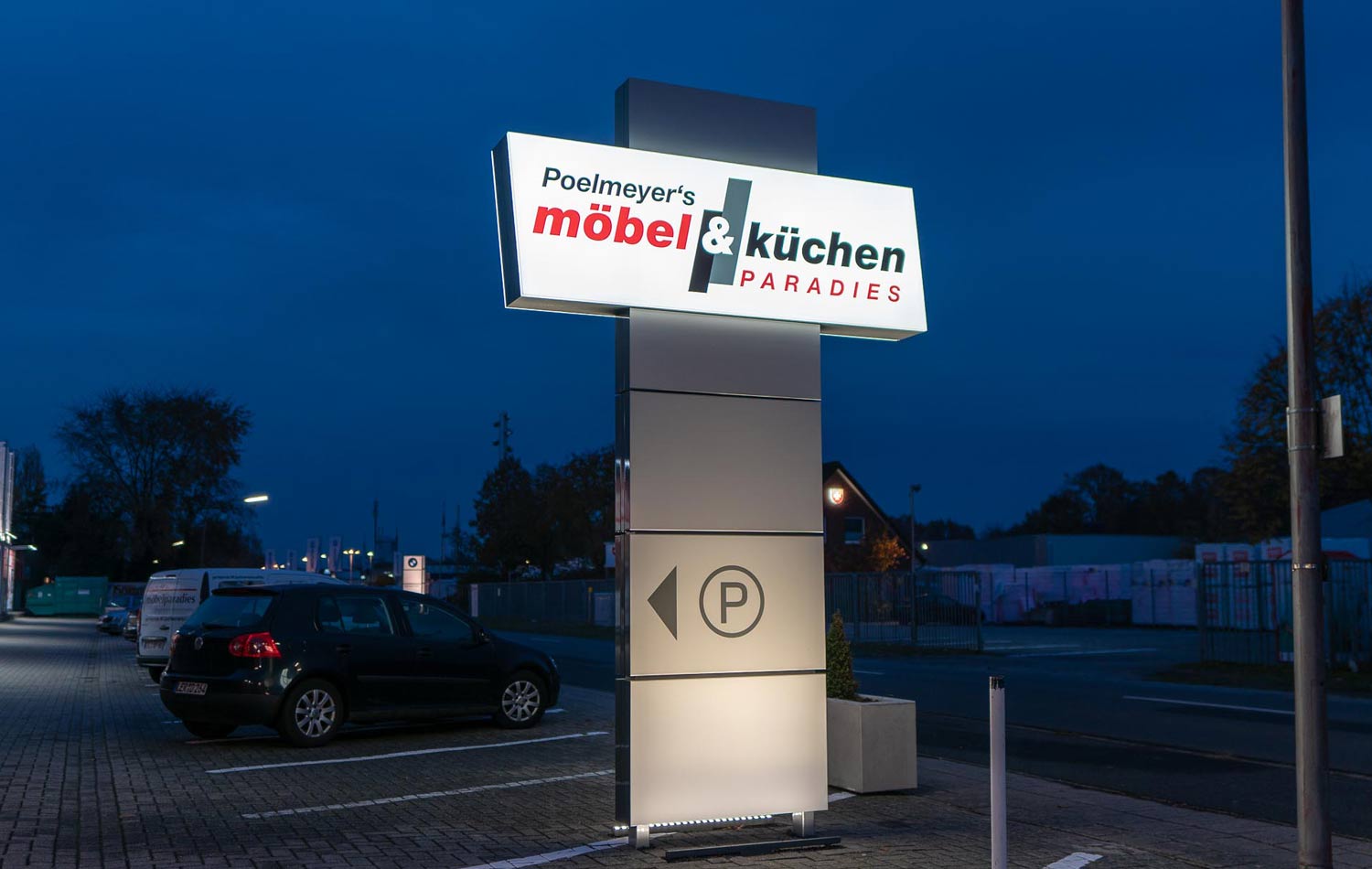 Ein Auto parkt vor einem Schild mit der Aufschrift „Küchen“