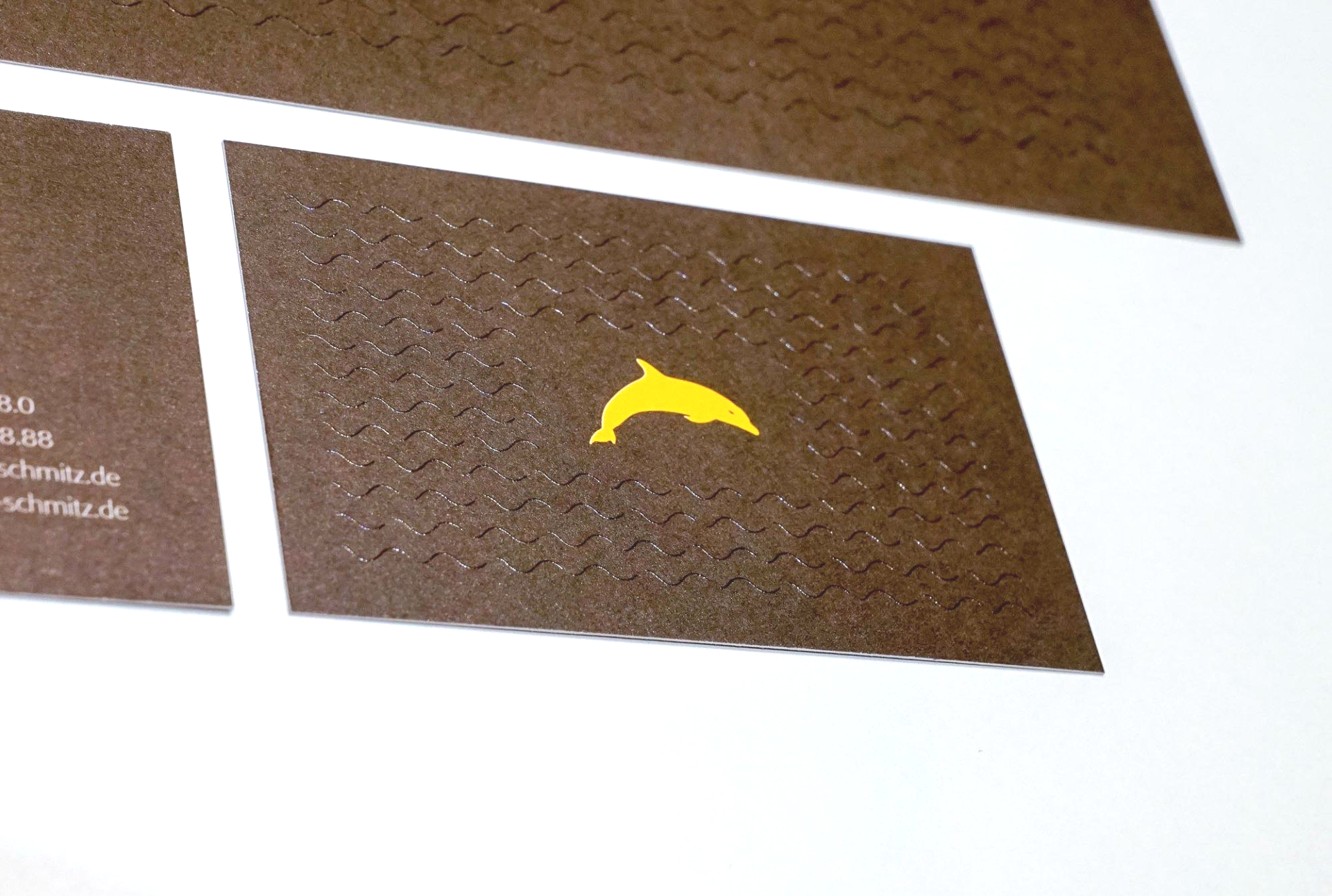 Eine Visitenkarte mit einem gelben Delphin darauf