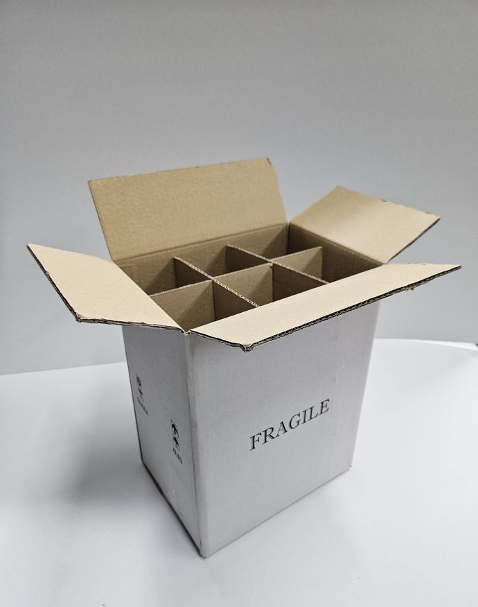Scatola di cartone aperta con divisori, etichettata 