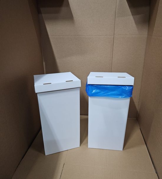 Due scatole rettangolari bianche con coperchio, una delle quali con un sacco della spazzatura blu