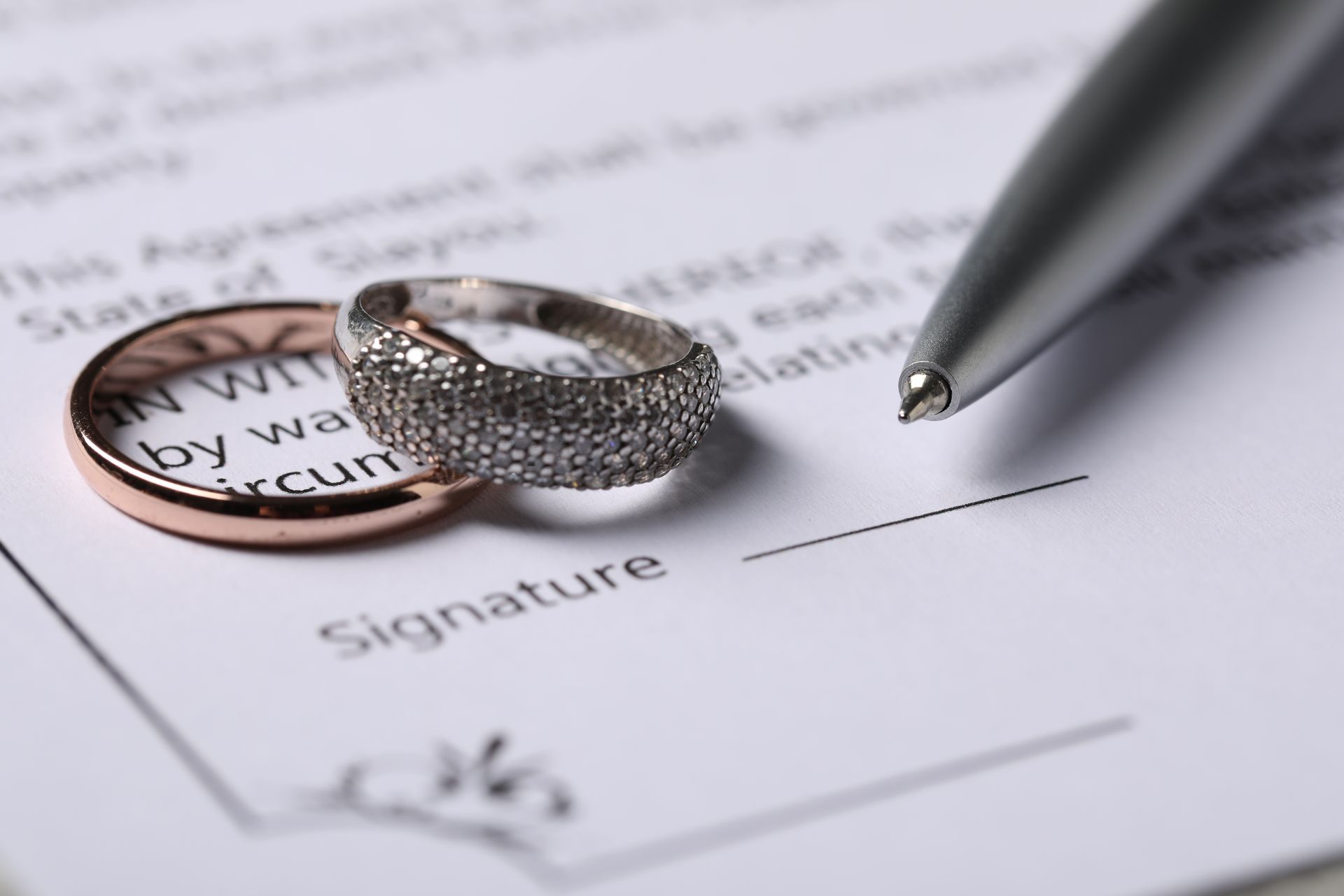 Wedding rings and pen on a document with 