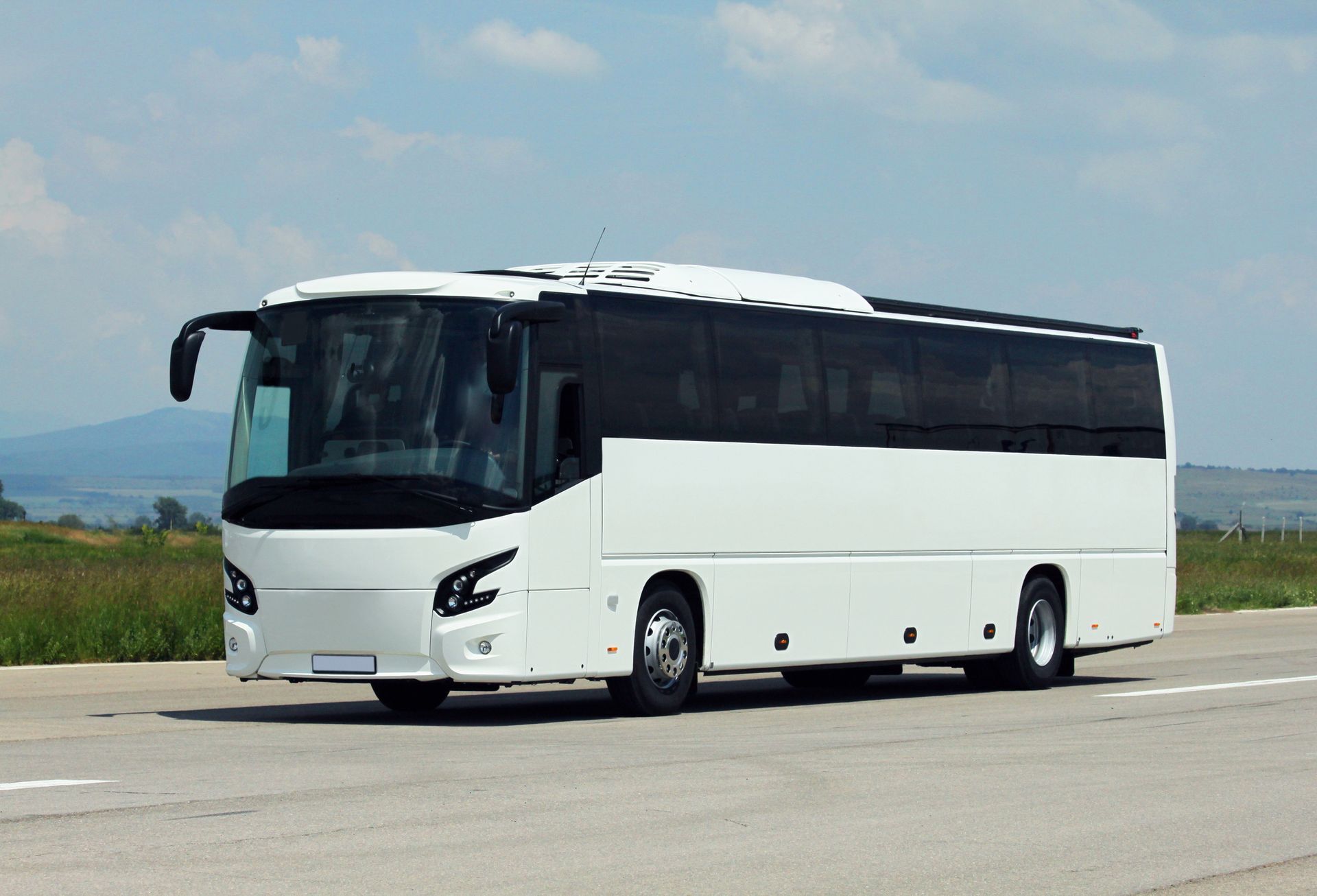 A white bus is parked on the side of the road.