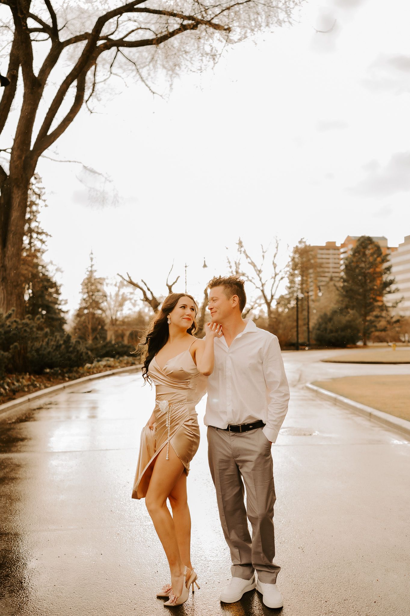 A man and a woman are walking down a wet street.