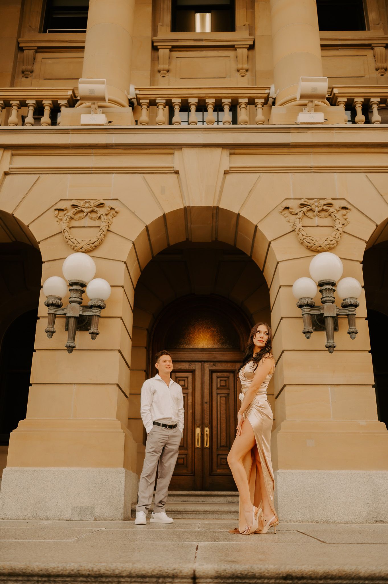 A man and a woman are standing in front of a building.